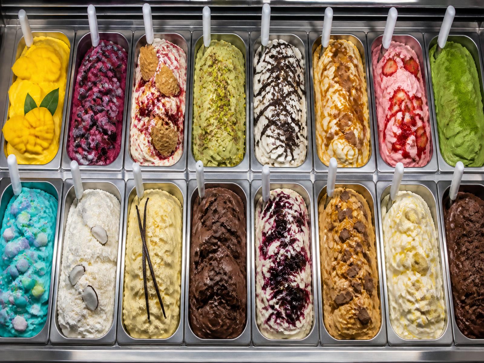 Gelato display freezer filled with rows of vibrant freshly made gelato pans